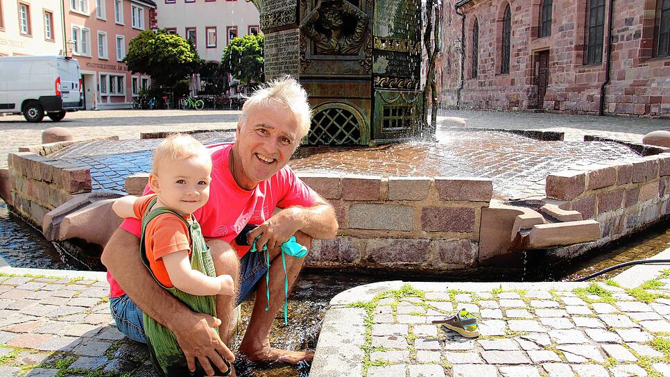 Frank Lehmann und seine Enkelin Maja kühlen ihre Füße im Villinger Stadtbächle ab.