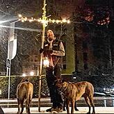 Udo Schulz mit dem beleuchteten Holzkreuz und seinen beiden Cane Corso-Hunden.