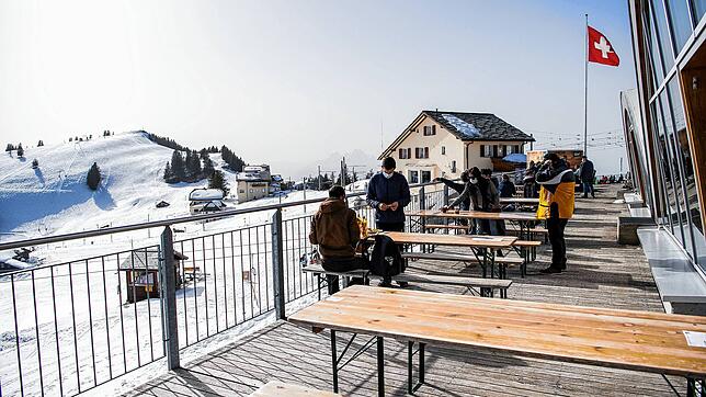 Besucher sitzen auf der Terrasse des Restaurants Bahnhöfli im Skigebiet auf der Rigi im Kanton Schwyz.