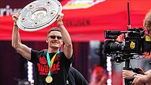 Leverkusens Florian Wirtz präsentiert bei der Meisterfeier in der BayArena die Meisterschale. Nun kommt die Mannschaft um Wirtz auf die ...