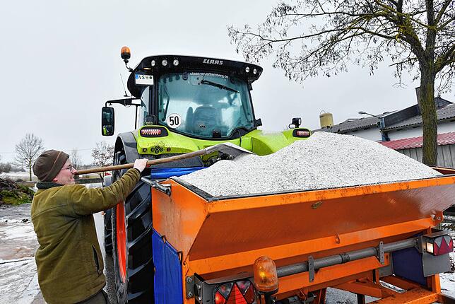 Im Kampf gegen den Eisregen im Städtedreieck: Lukas Binninger vom Maschinenring belädt seinen Traktor mit Salznachschub.