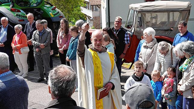 Pfarrer Bernhard Stahlberger zelebriert den Gottesdienst und anschließend segnet er die 30 Traktoren und die Menschen, die sie fahren. ...