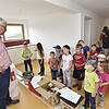 Kindergarten-Neubau in Behla: 20 Kinder vom Kindergarten St. Maria Hausen vor Wald besichtigen im Sommer unter der Leitung von Architekt ...