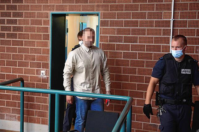 Justizmitarbeiter bringen einen der vier Angeklagten in die Verhandlung.